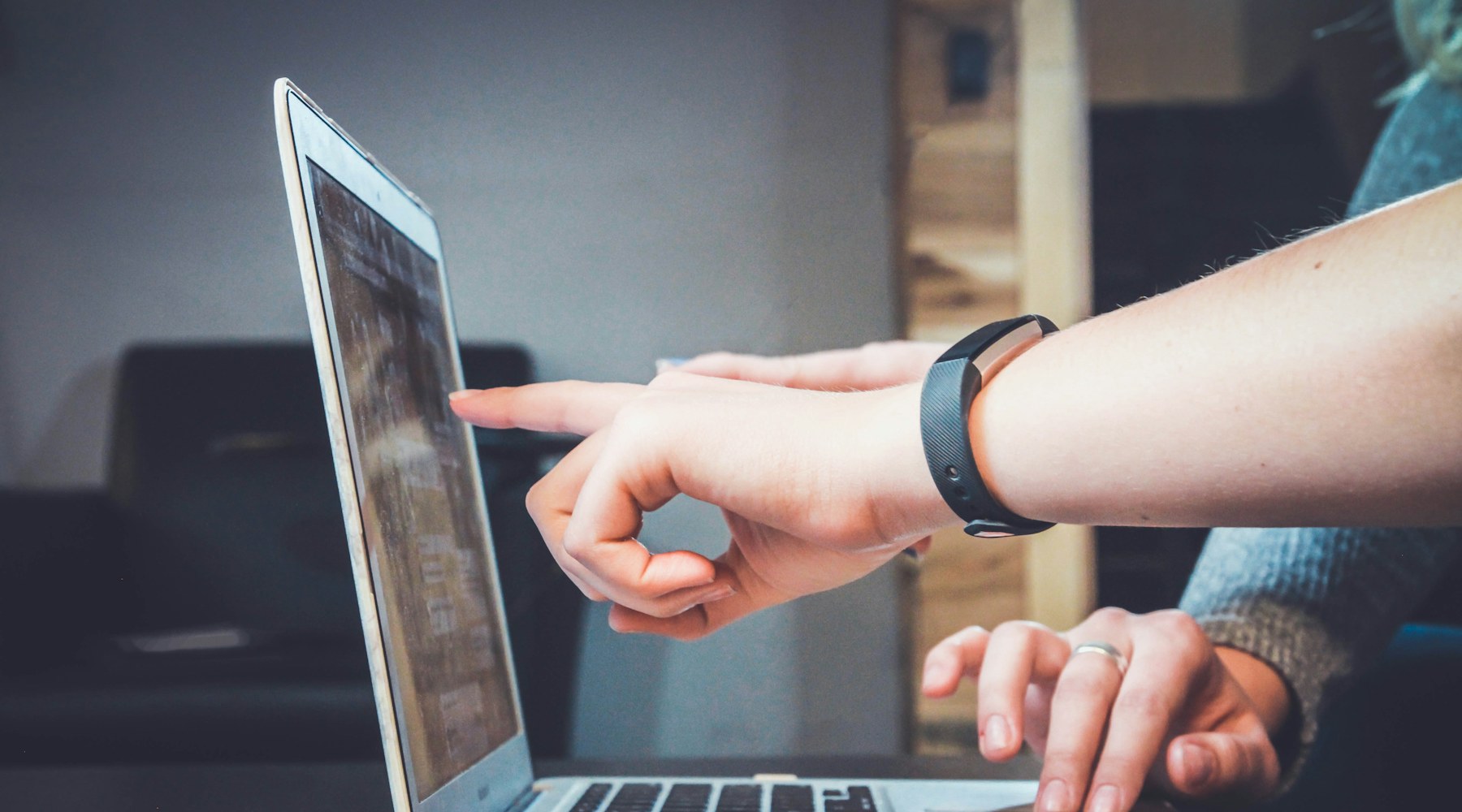 Zwei Personen arbeiten gemeinsam am Laptop und bereiten digitale Qualitätsprozesse vor